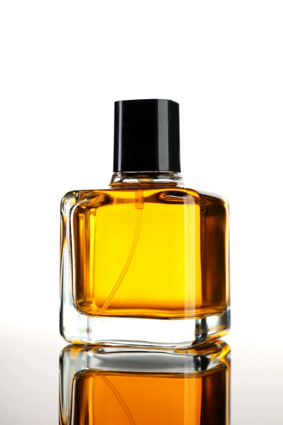 Real photograph of a clear glass perfume bottle with a black cap