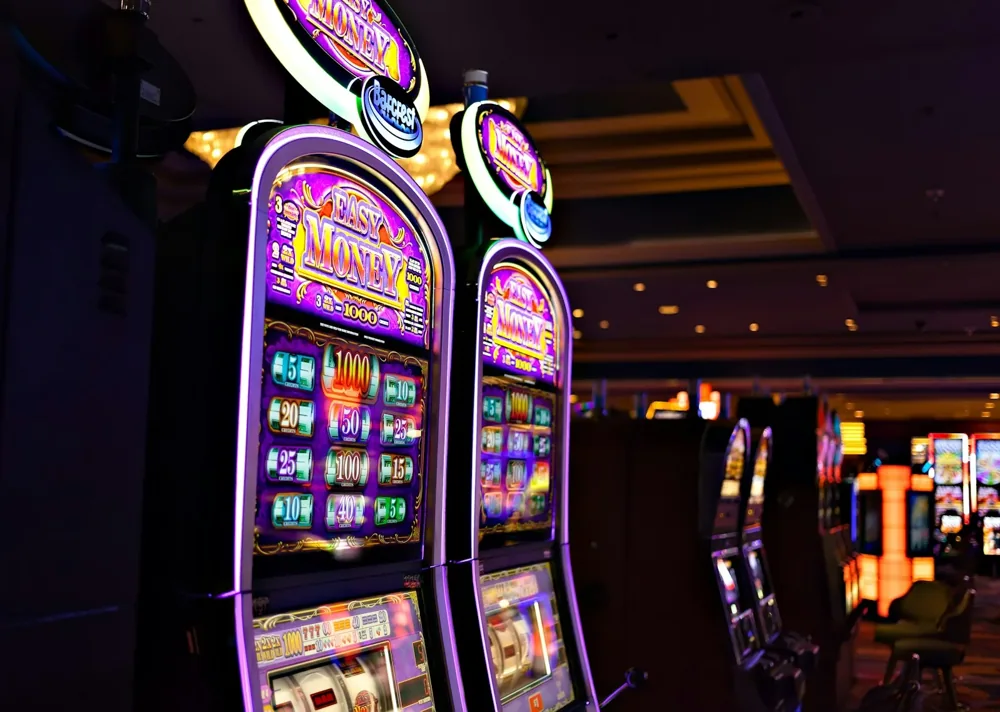 A row of illuminated slot machines in a Las Vegas casino