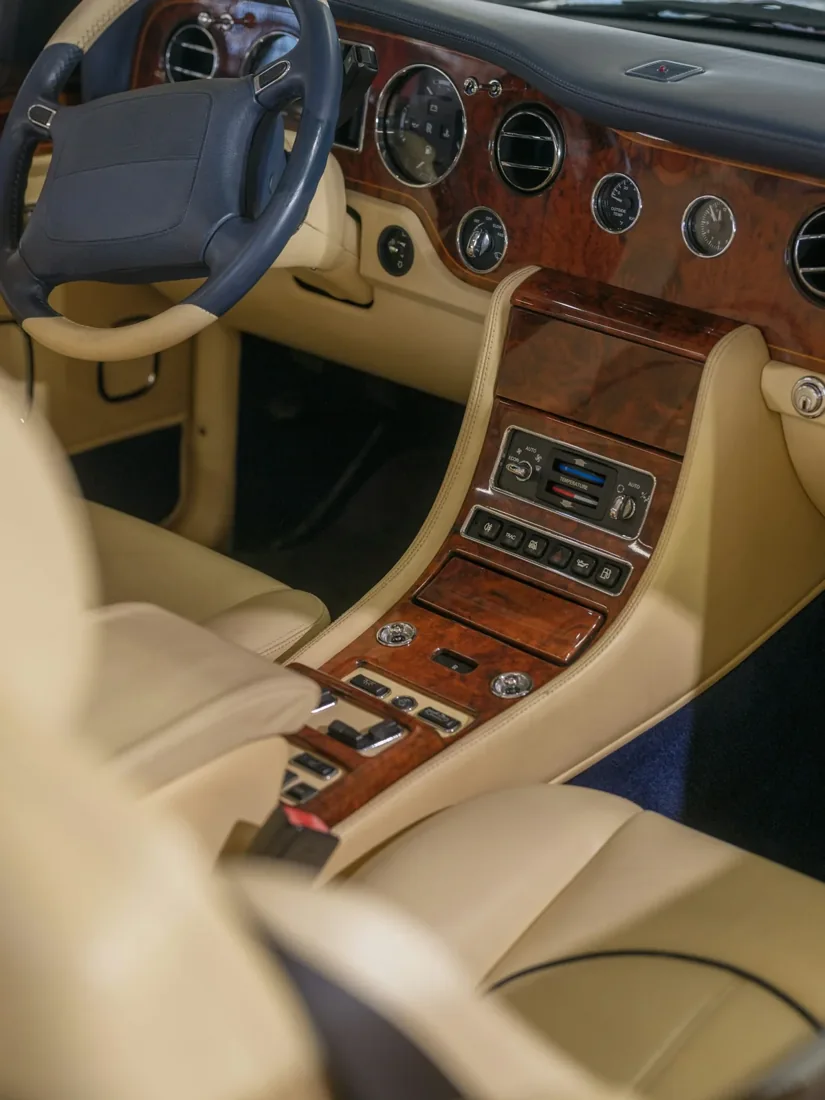 A Rolls Royce cabin with polished wood and cream leather