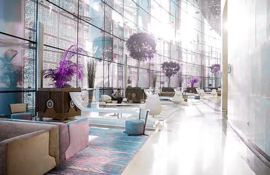 A tall glazed lobby with seating and an open arrival area